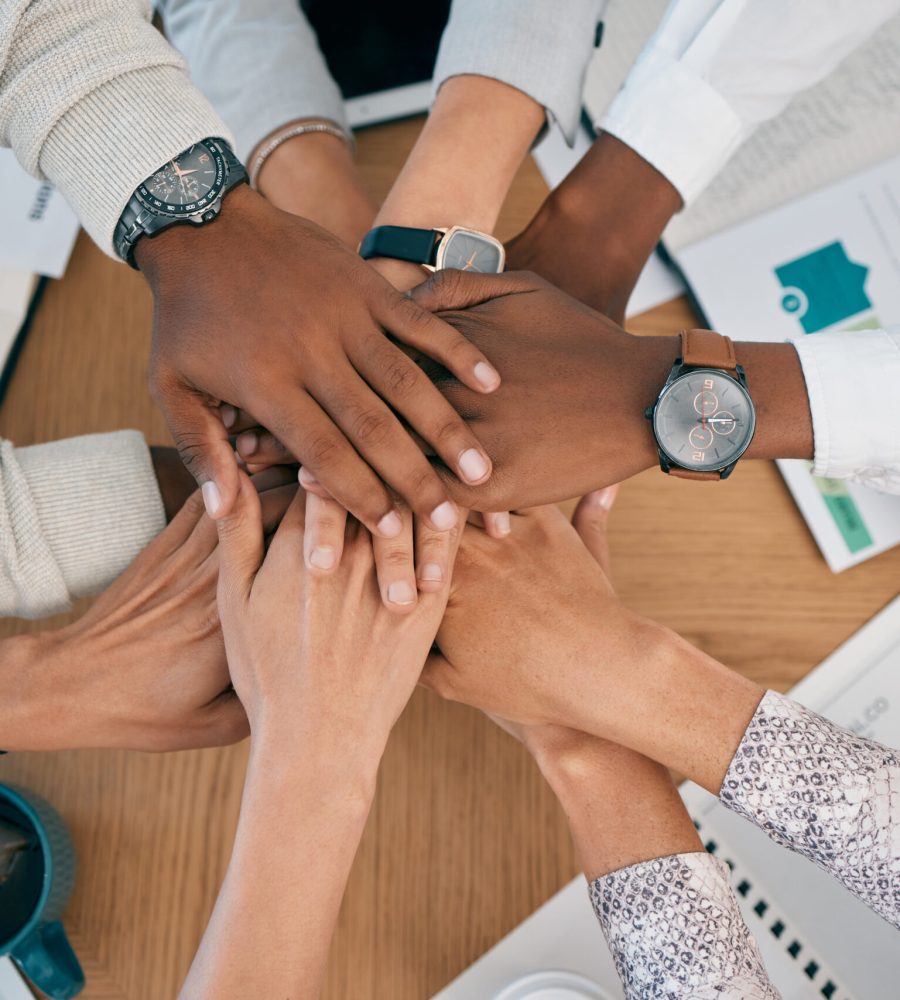 Teamwork, collaboration and stack of hands with documents, analytics report and infographics on desk. Support, diversity and top view of business people hands for community, partnership and trust